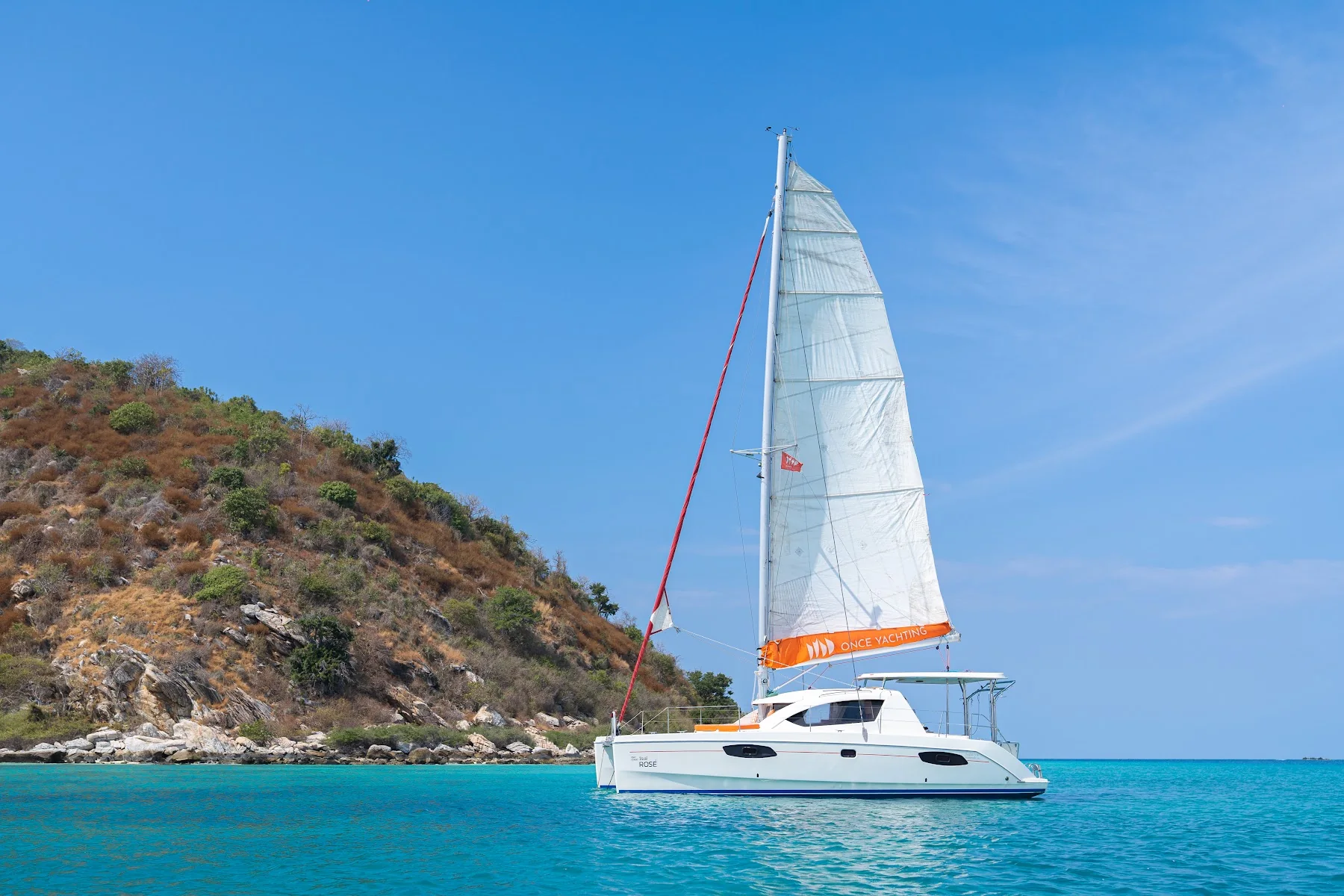 Rosé sailing catamaran in coastal waters
